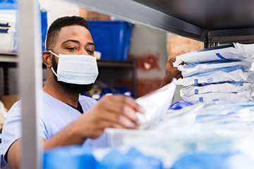 Masked worker reviewing medical inventory